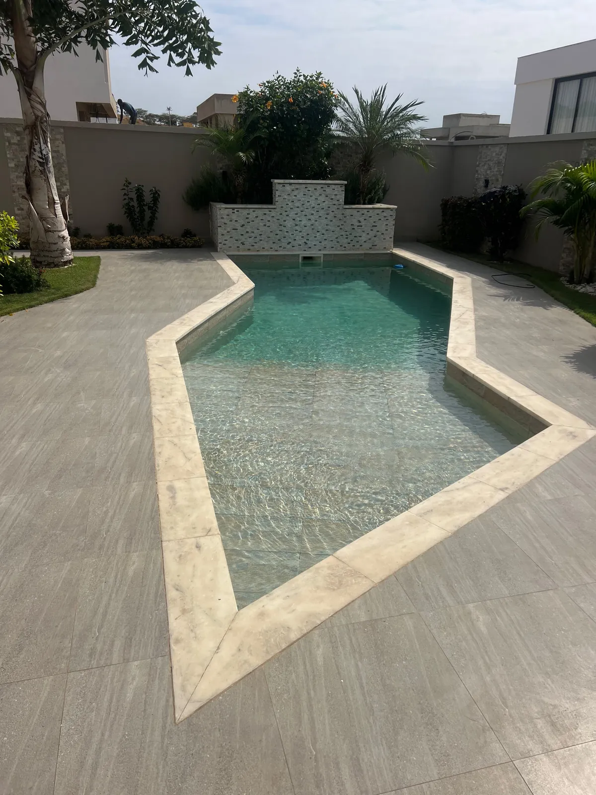 Piscina residencial com pavimento exterior e paisagismo